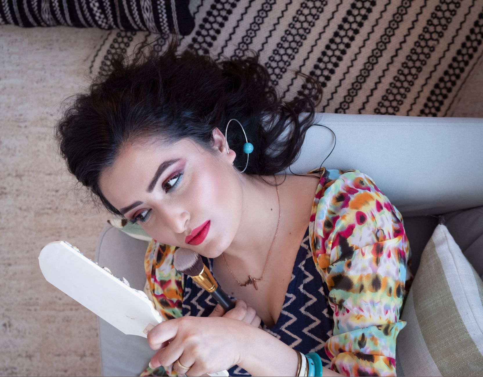 Portrait of a woman in vibrant attire looking in mirror, capturing elegance and style.