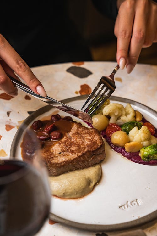 Woman with Cutlery Eating Meal in Restaurant