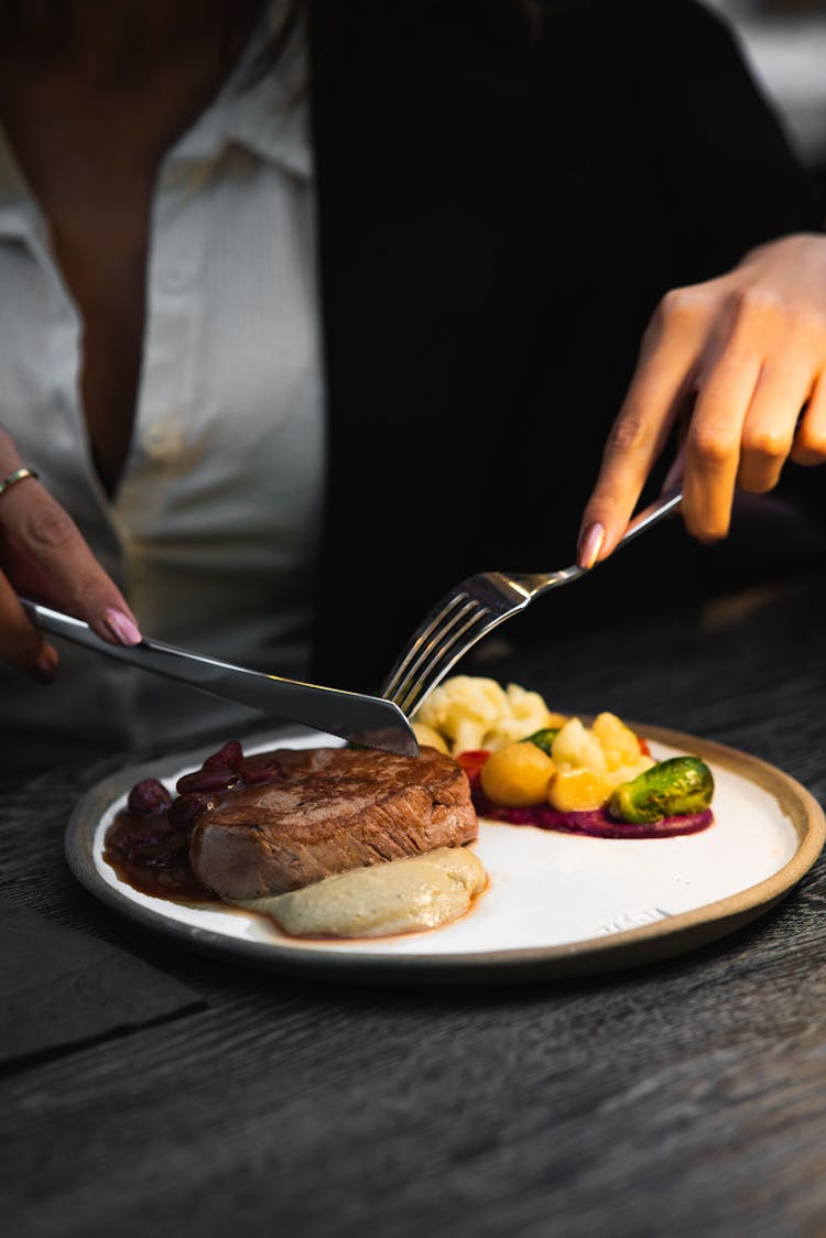 Person Slicing A Steak