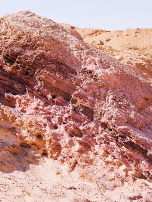 A striking eroded rock formation in a desert landscape under a clear blue sky.