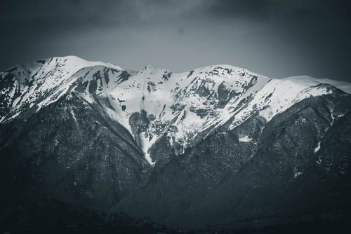 Free Stunning view of snow-covered mountain peaks with dramatic, moody atmosphere. Stock Photo