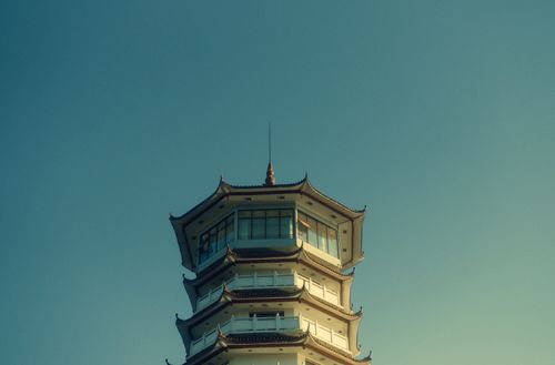 Free Elegant pagoda tower with traditional architecture set against a clear blue sky. Stock Photo