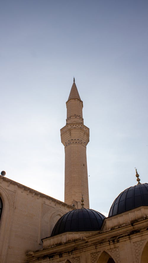 Minaret over the Domes of the Mosque Against the Blue Sky