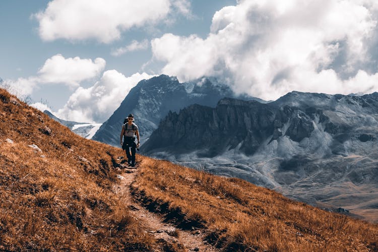 Man Hiking Through Mountains