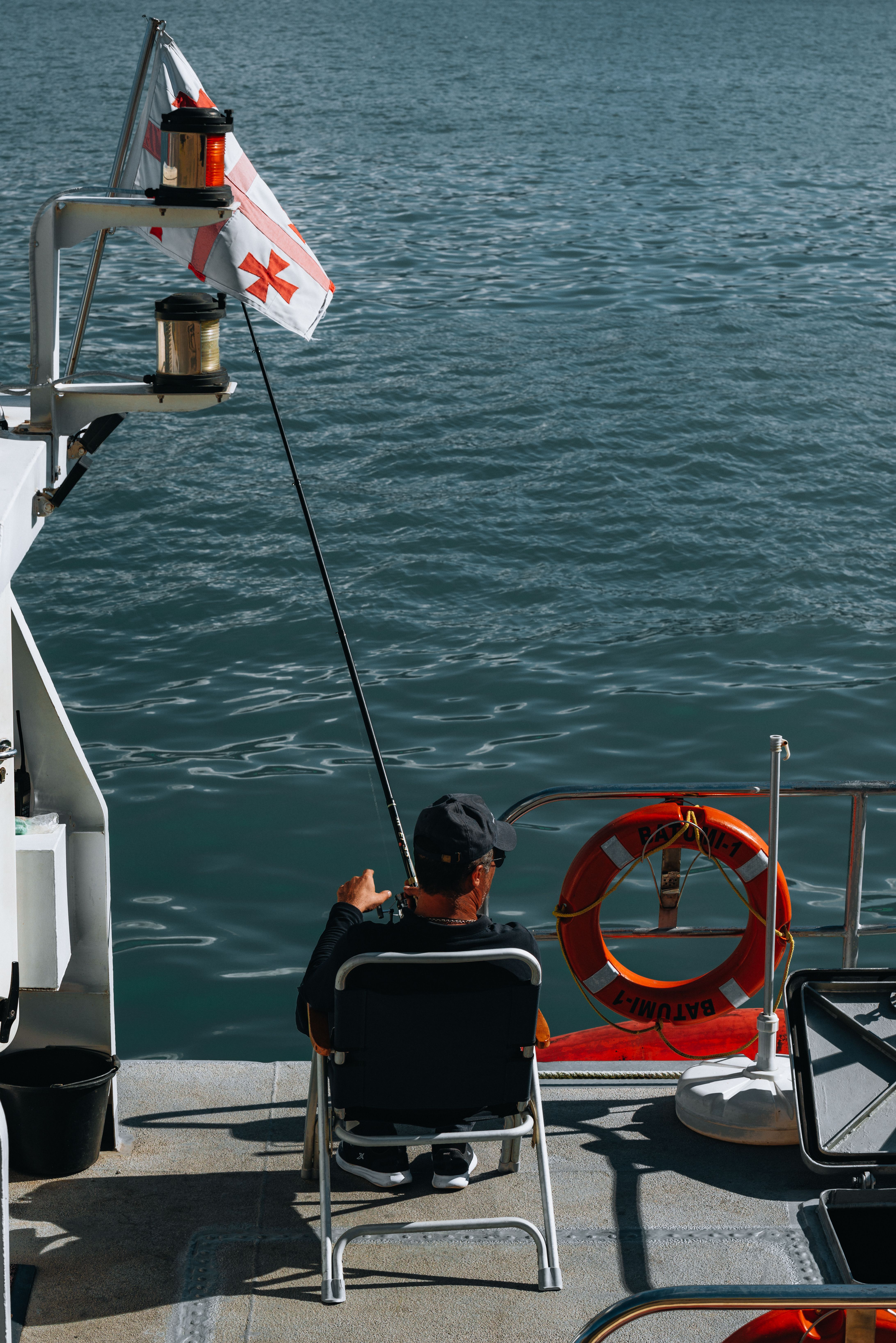 A man holding a fishing rod on a boat at sea