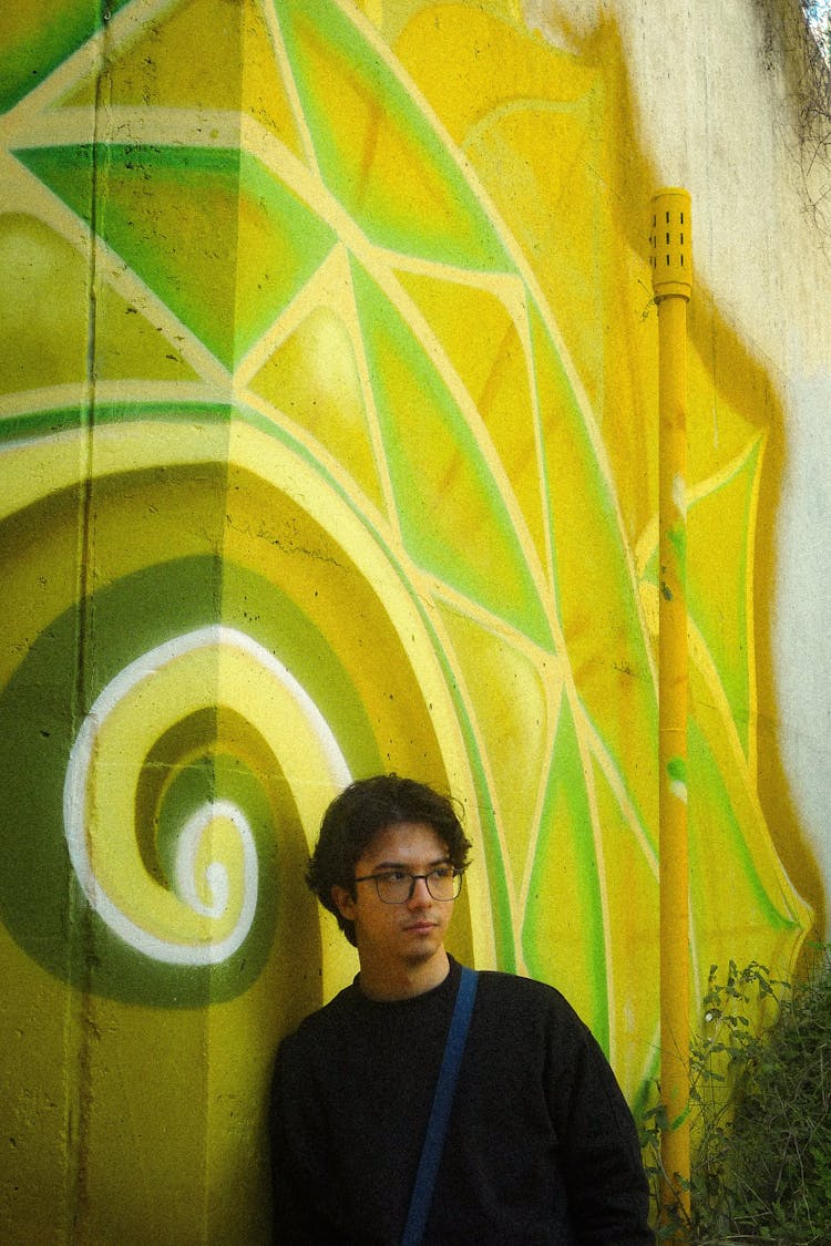 Man Posing Near Wall With Mural