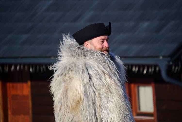 Man In Fur Near House