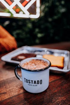 Warm coffee served in a TOSTADO mug with snacks on a wooden table in São Paulo.