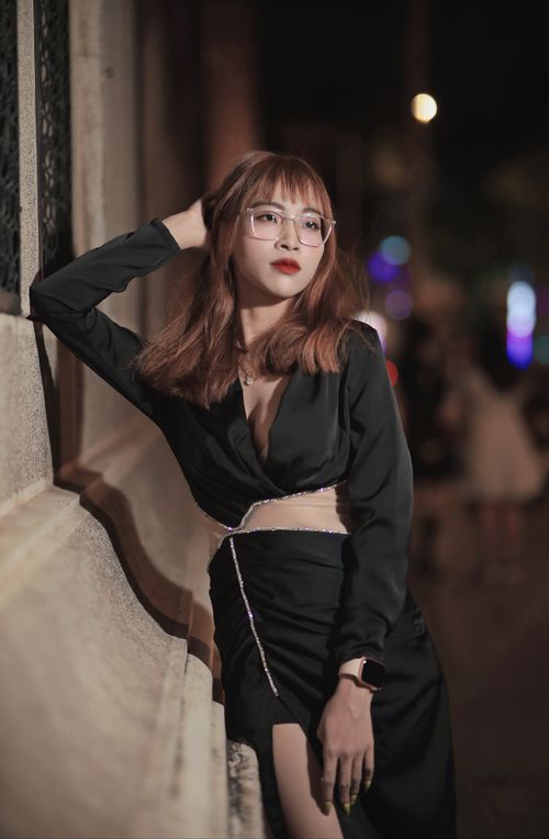 Free Young woman in black dress poses stylishly at night showcasing modern fashion trends. Stock Photo