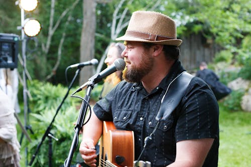 Man Singing while Playing the Guitar