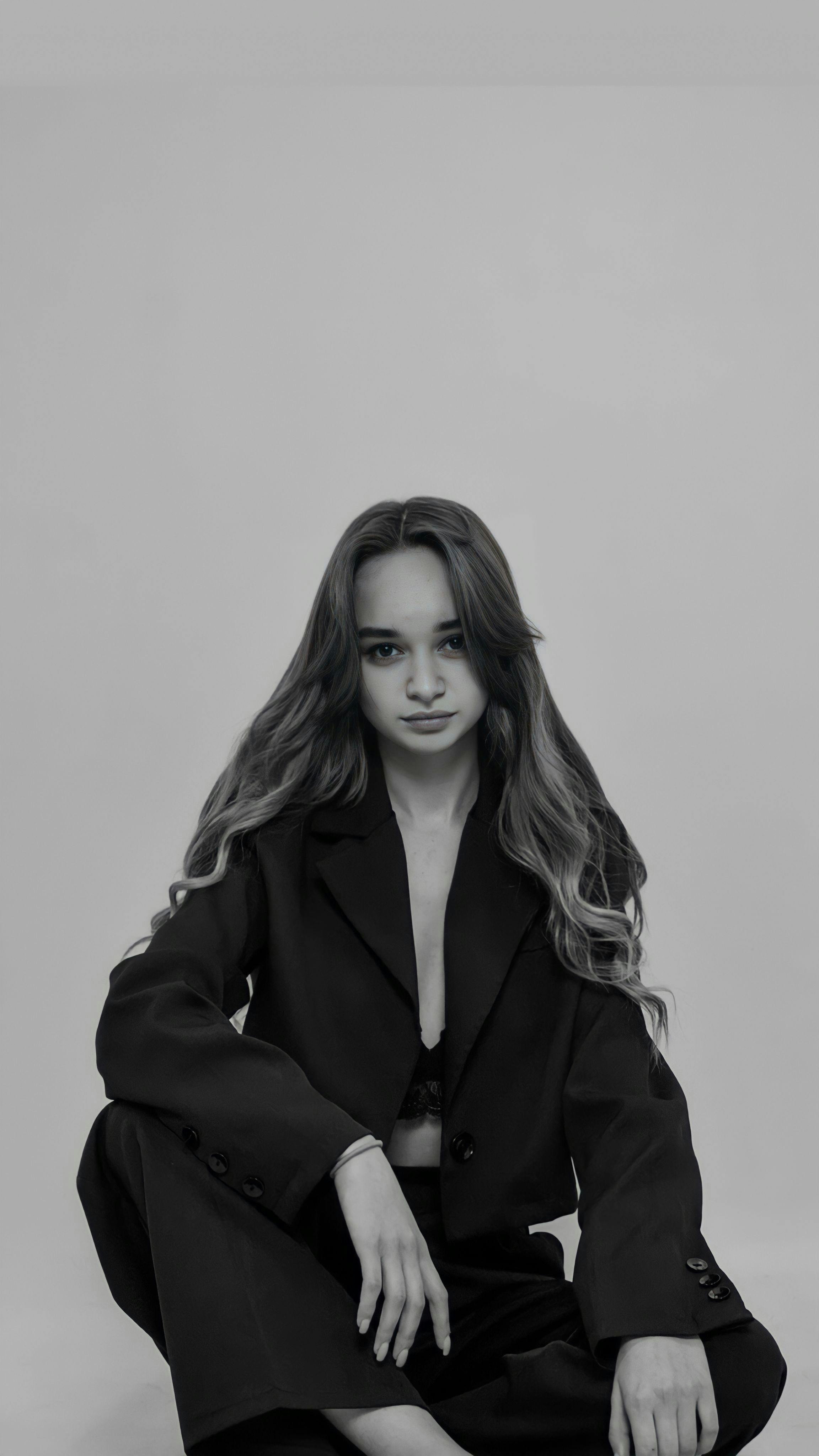 Stylish black and white portrait of a woman with long hair in a fashionable pose.