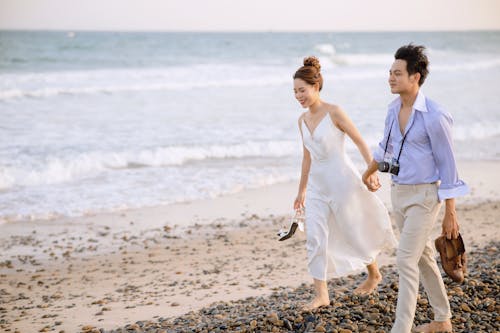 Free Couple Walking on the Beach Holding Hands  Stock Photo