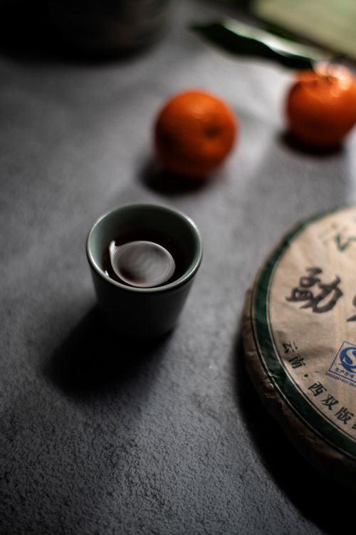 Free Chinese tea served in a cup with fresh oranges on a slate surface, creating a cozy ambiance. Stock Photo