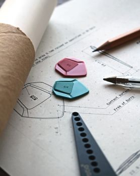 An artistic workspace featuring guitar picks, drafting tools, and creative sketches.