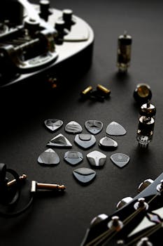 A stylish collection of guitar accessories including various picks, tubes, and cables arranged artistically for musicians.