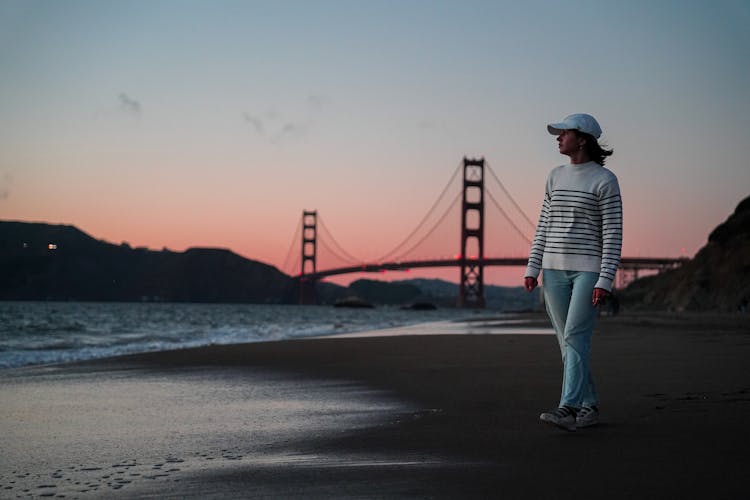 Tourist Walking On Baker Beach In San Francisco At Dusk