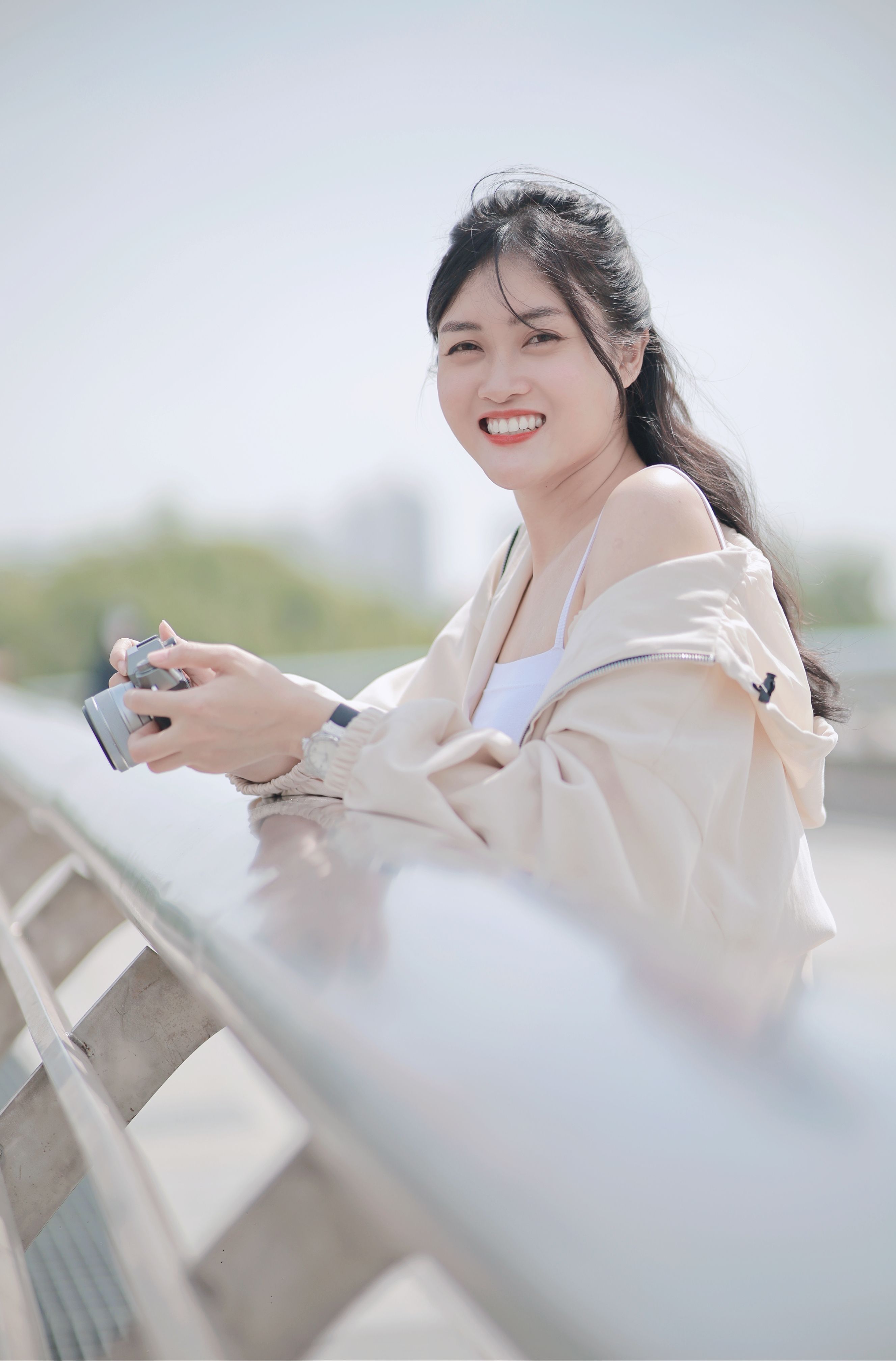 Young Woman Smiling and Holding a Camera