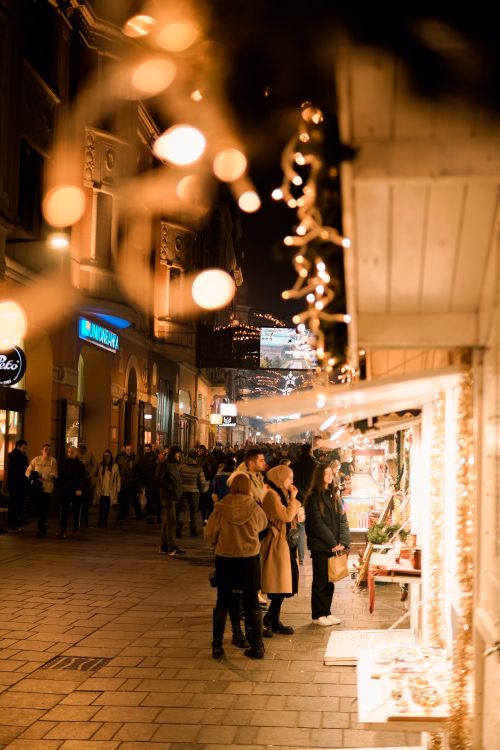Free People enjoying a festive Christmas market adorned with sparkling lights. Stock Photo