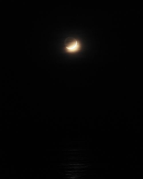 Free A captivating view of a crescent moon illuminating the night sky with a soft glow. Stock Photo