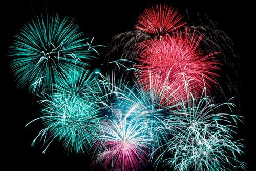 Free A stunning display of colorful fireworks illuminating the night sky, showcasing vibrant reds and blues. Stock Photo