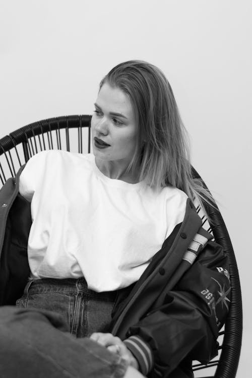 Free A Woman in White Shirt Sitting on a Chair Stock Photo