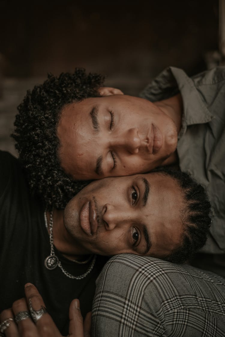 Two Men Sitting Close Together With Head On The Knee