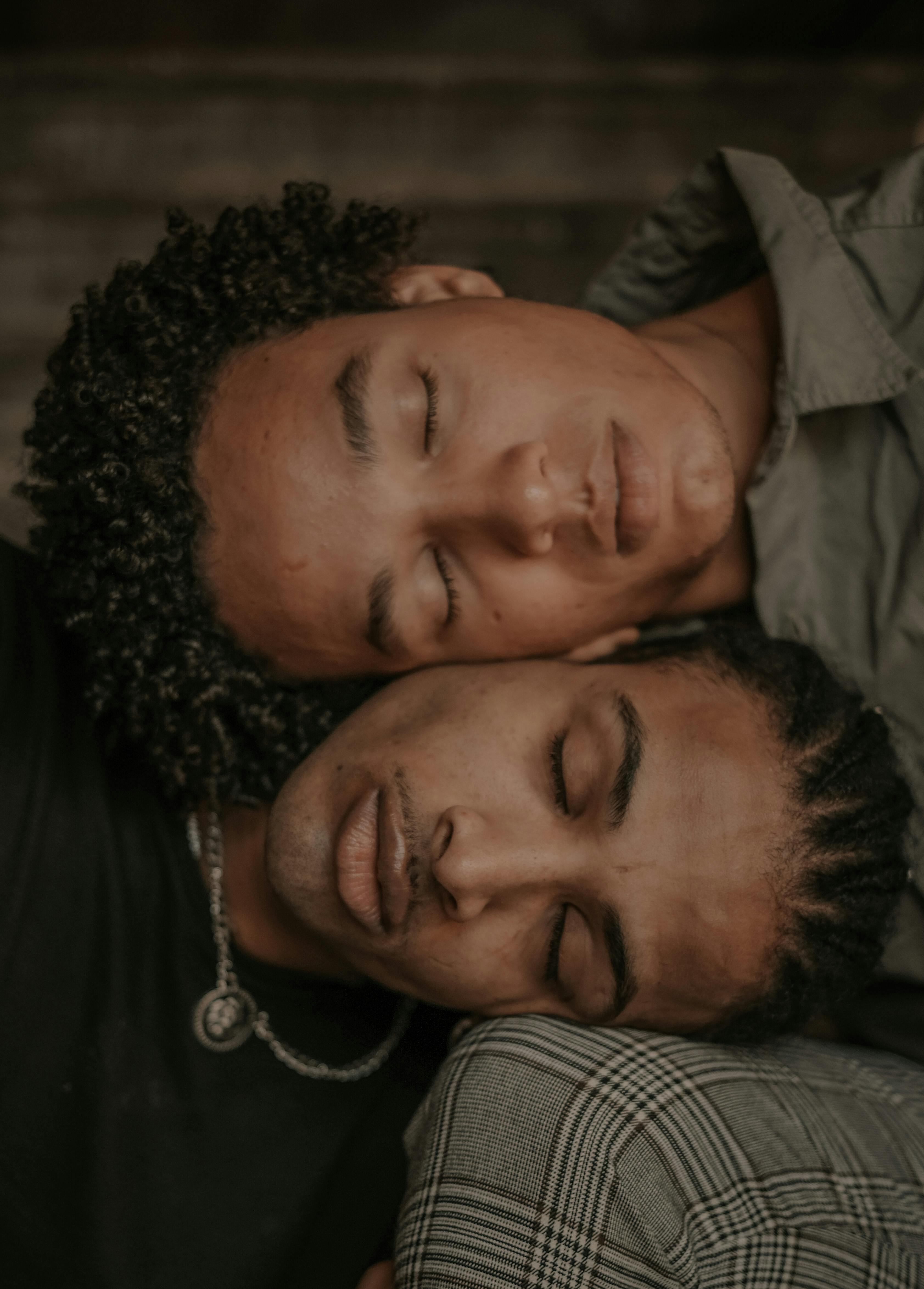 two men with their heads together and closed eyes
