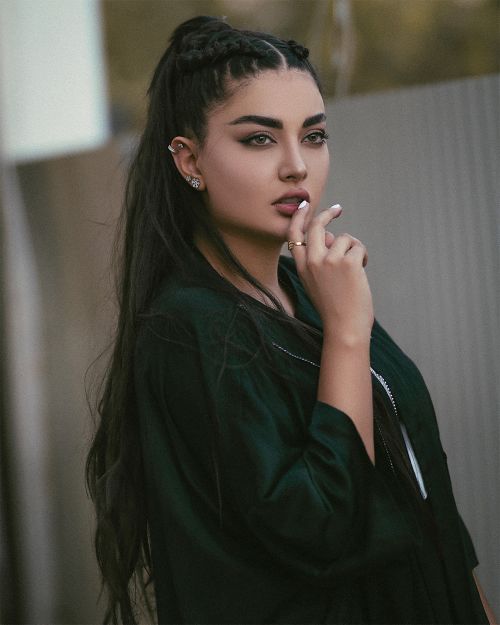 Free Stylish portrait of a young woman with braided hair and black attire, showcasing elegance and confidence. Stock Photo