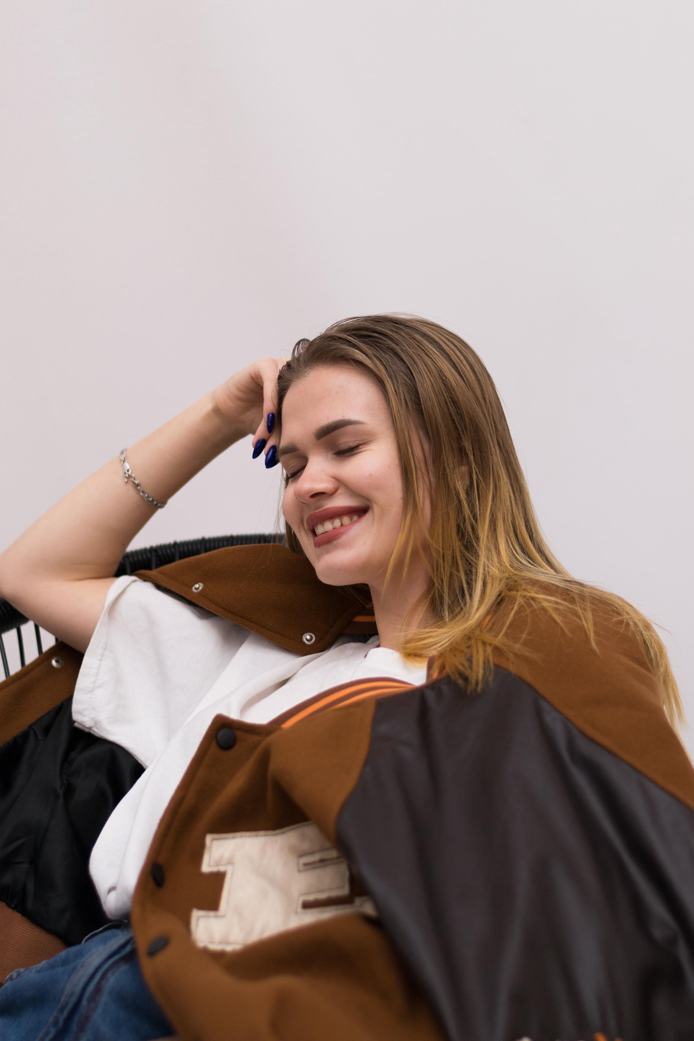 Portrait of a Young Woman Sitting and Smiling · Free Stock Photo