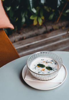 A delicious cold soup served in a glass bowl on a stylish table, perfect for a refreshing meal.