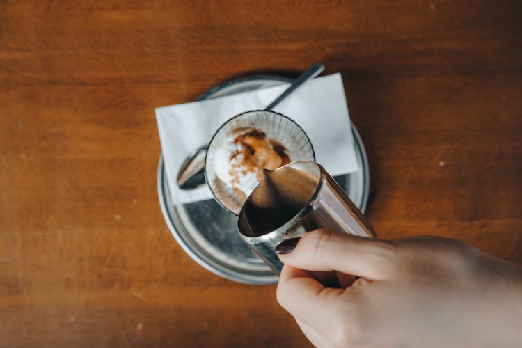 Hand Pouring Coffee In Glass Cup