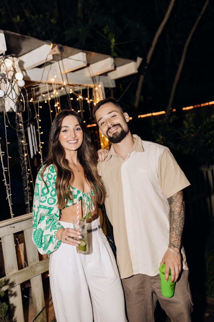 Young Man And Woman Holding Cocktails At A Party 