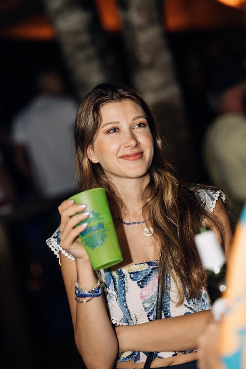 Smiling Woman with Drink in Nightclub