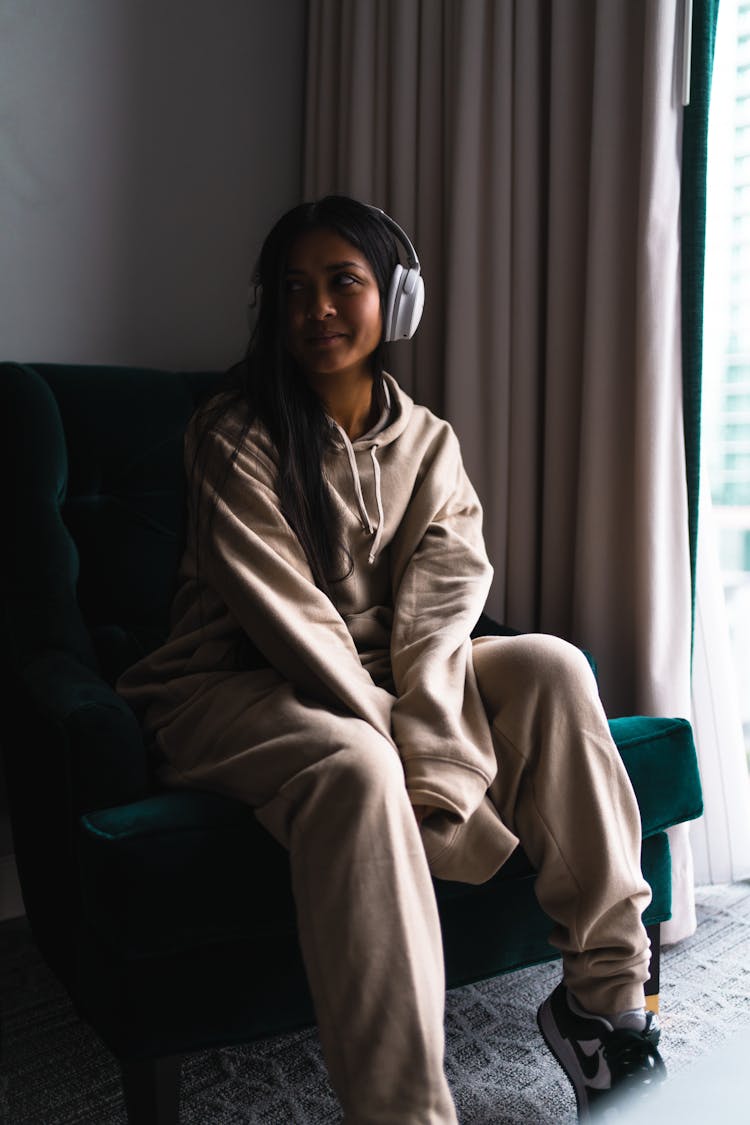 Woman With Headphones Sitting On Sofa