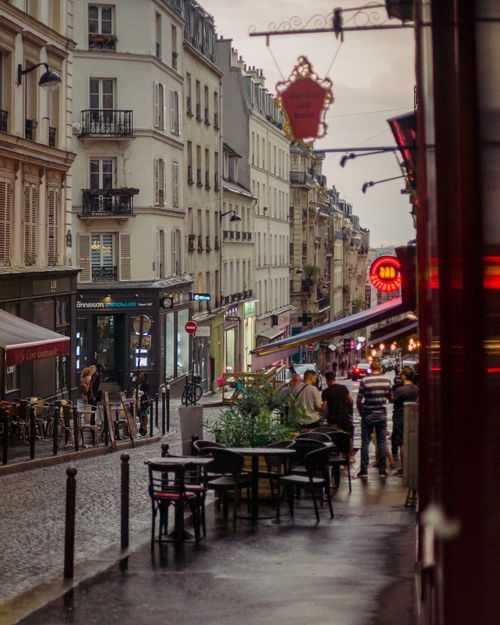 Free A twilight view of Parisian street with cafes and pedestrians. Stock Photo