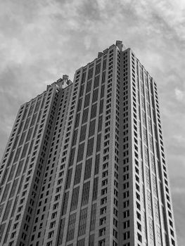 A towering black and white skyscraper in Atlanta under a cloudy sky.