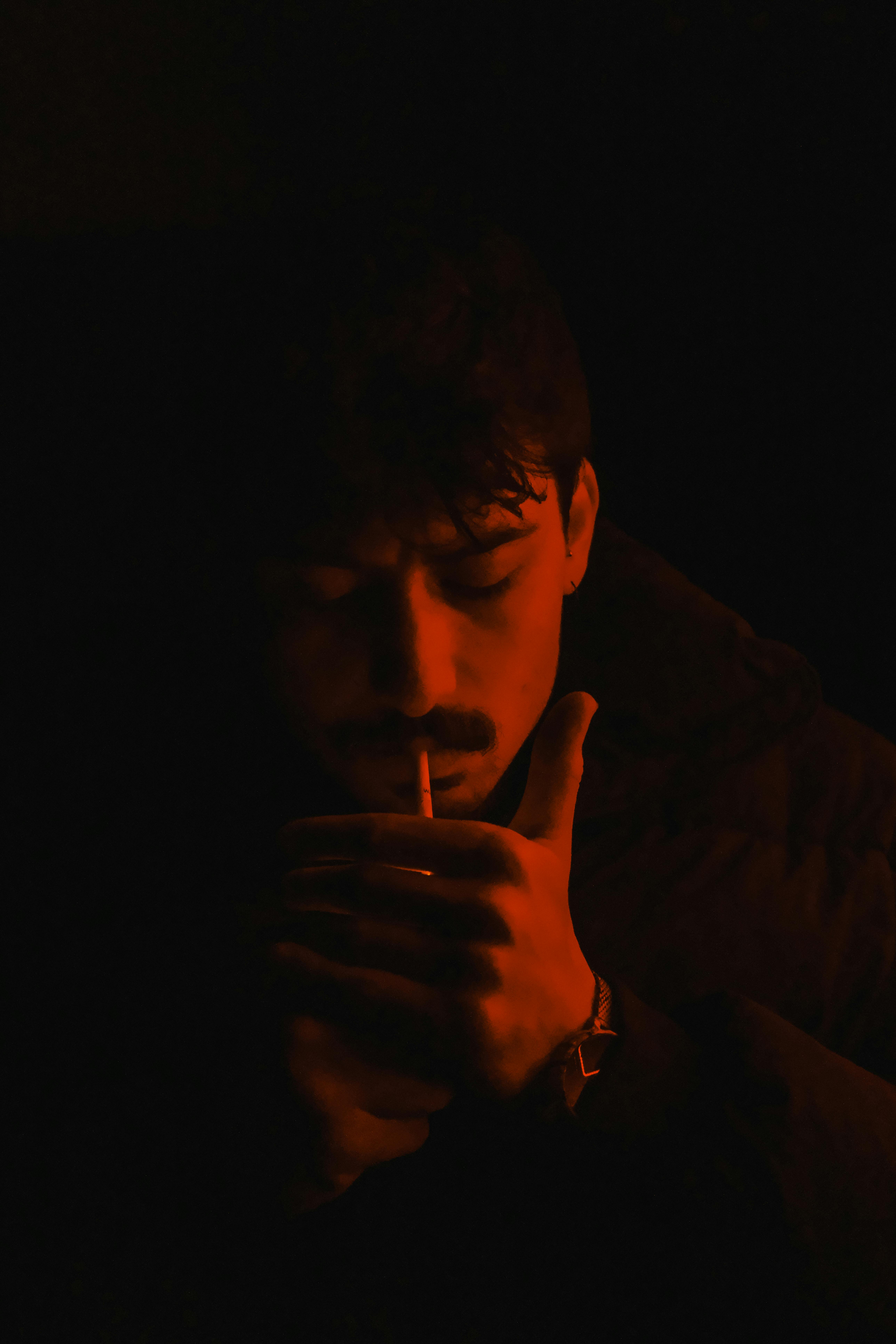 man smoking in a dark room