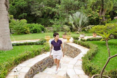 Woman with Short Hair Walking Path in Green Garden