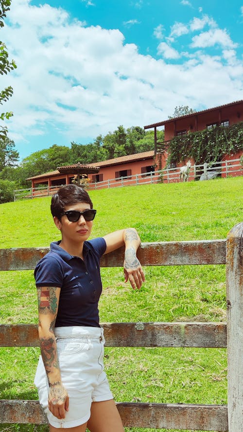 Woman with Short Hair Posing near Fence in Countryside