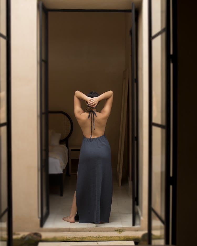 Woman In A Long Dress Standing In The Bedroom 