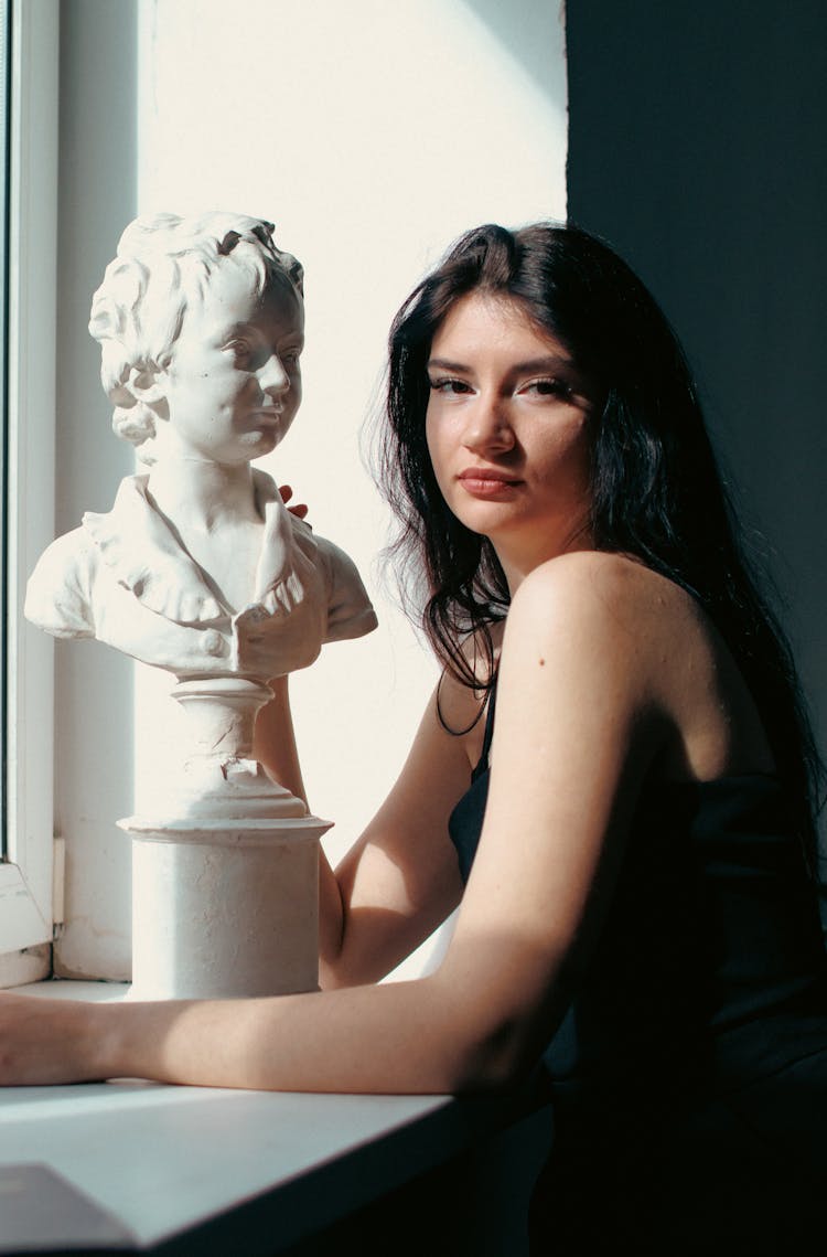 Brunette Woman Posing Next To Bust