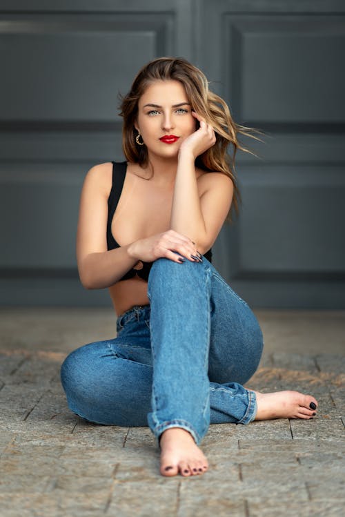 Beautiful Woman in Blue Jeans Sitting on the Floor 