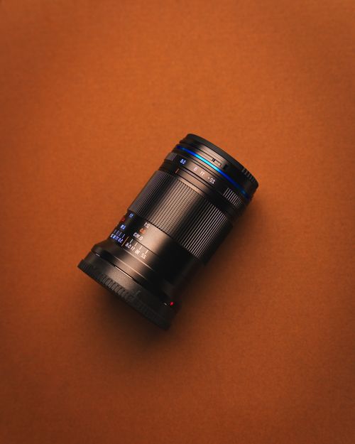 Free A detailed view of a camera zoom lens set against a brown background. Stock Photo