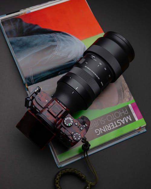 Free Photo of a Black Digital Camera Lying on the Opened Book Stock Photo