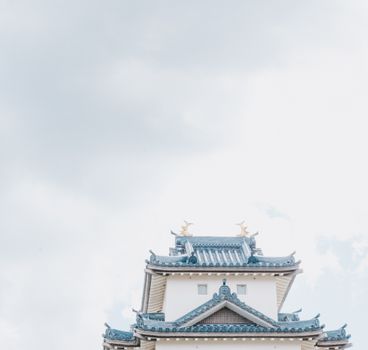 Elegant view of a traditional Japanese castle rooftop against a bright sky.