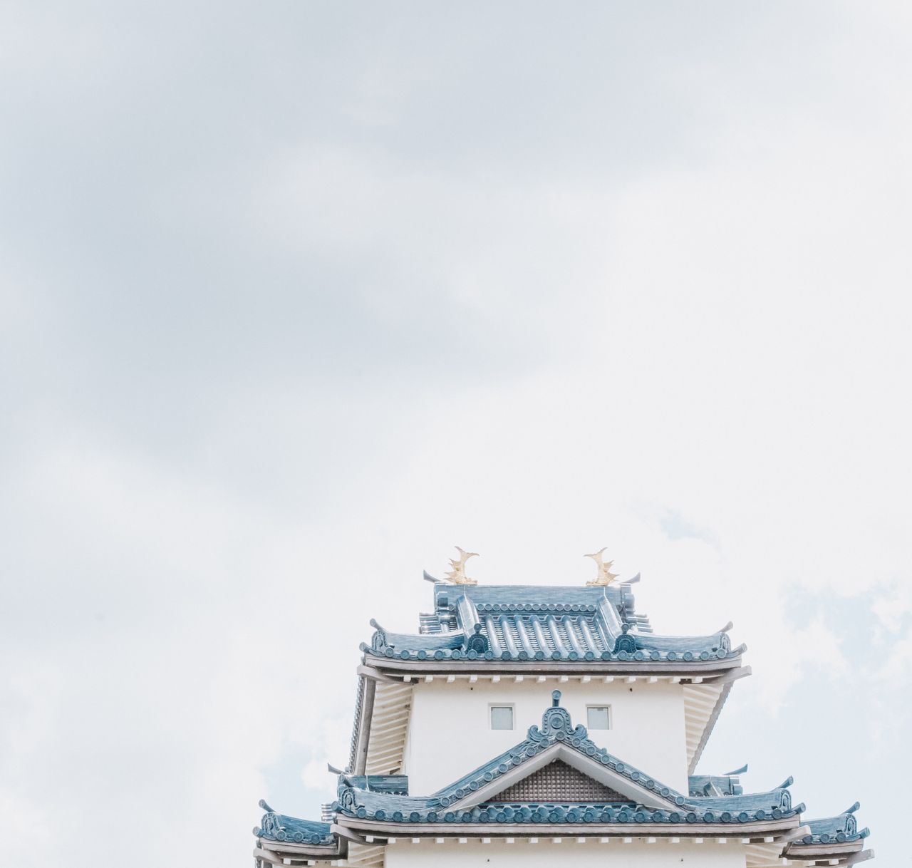 elegant view of a traditional japanese castle rooftop against a bright