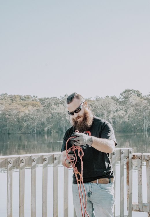 Untangling A Rope Man Untangling Rope on a Bridge · Free Stock Photo