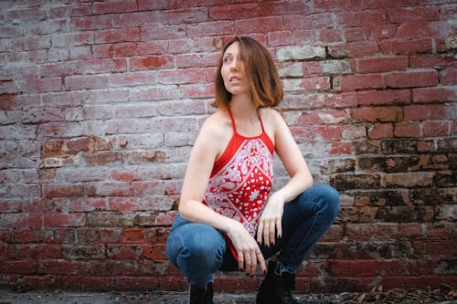 Woman Crouching and Posing by Wall