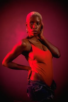 Bold portrait of a woman in vibrant red lighting, showcasing modern fashion style.