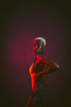 Dramatic studio portrait of a stylish woman with short hair and vibrant lighting effects.